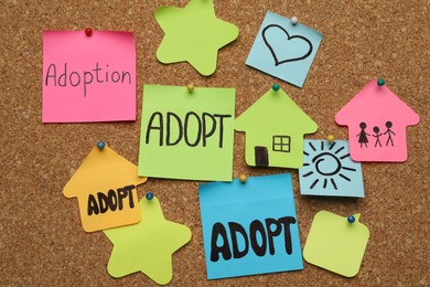 Photo of Many colorful notes pinned to cork board. Child adoption concept