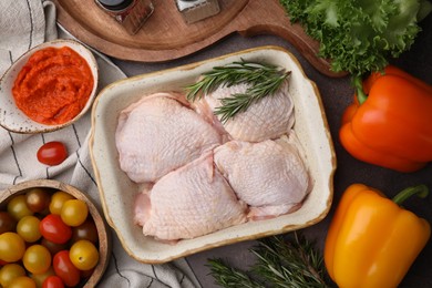 Flat lay composition with marinade, raw chicken, rosemary and other products on table