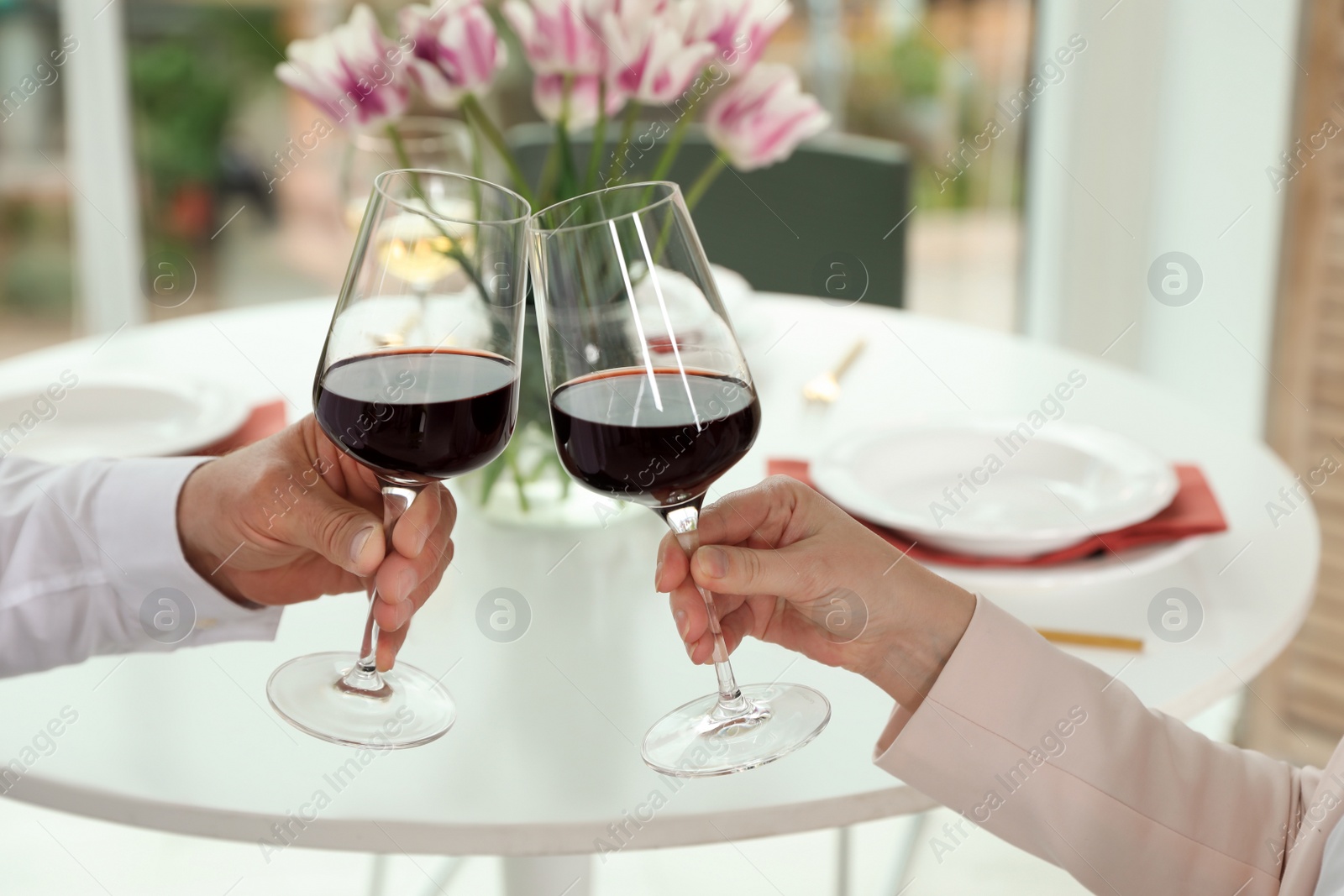 Photo of People with glasses of wine on blurred background, closeup