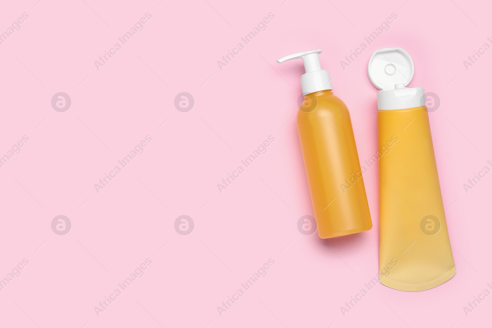 Photo of Different cleansers on pink background, flat lay with space for text. Cosmetic product