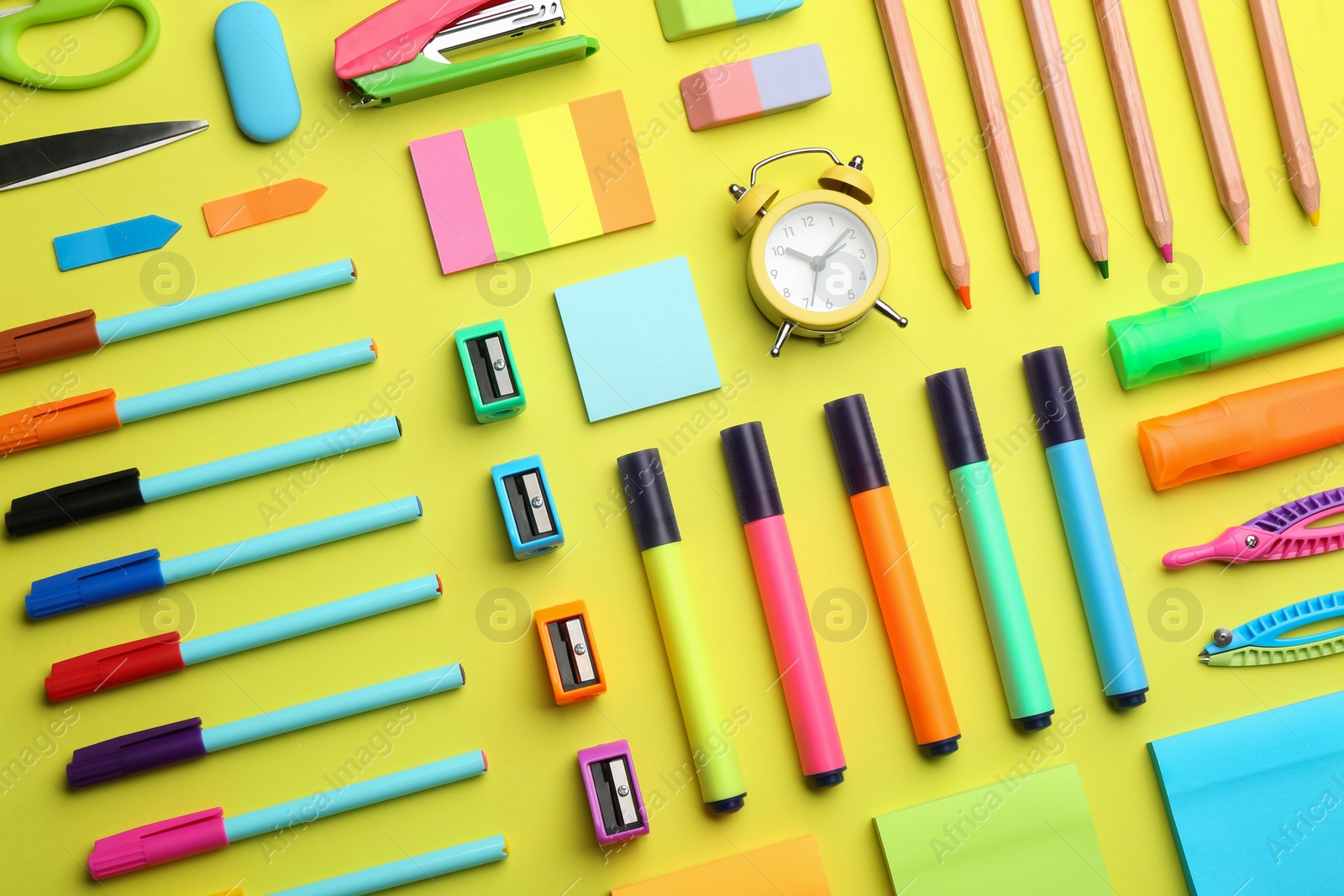 Photo of Flat lay composition with school stationery on yellow background. Back to school