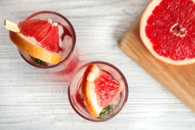 Photo of Flat lay composition with glasses of grapefruit cocktails on wooden table