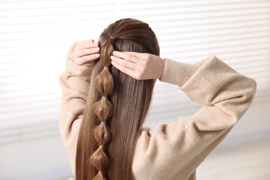 Photo of Woman with braided hair indoors, back view