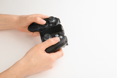 Photo of Young woman holding video game controller on white background, closeup