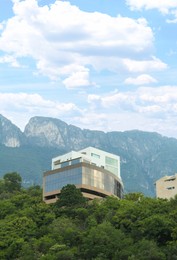 Beautiful view of buildings and green plants near mountains