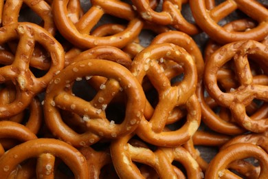 Photo of Many delicious pretzel crackers as background, closeup view