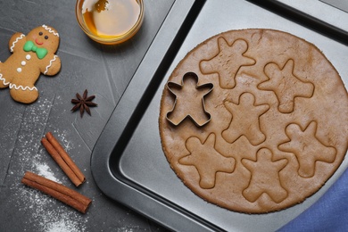 Photo of Making homemade gingerbread man cookies on grey table, flat lay