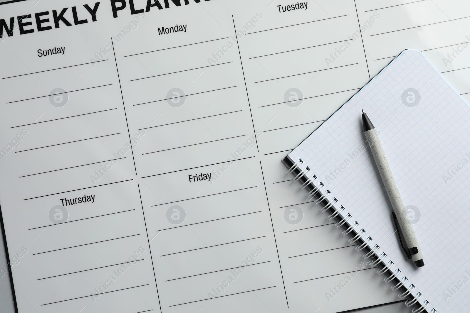 Photo of Timetable. Planner, notebook and pen on grey table, top view