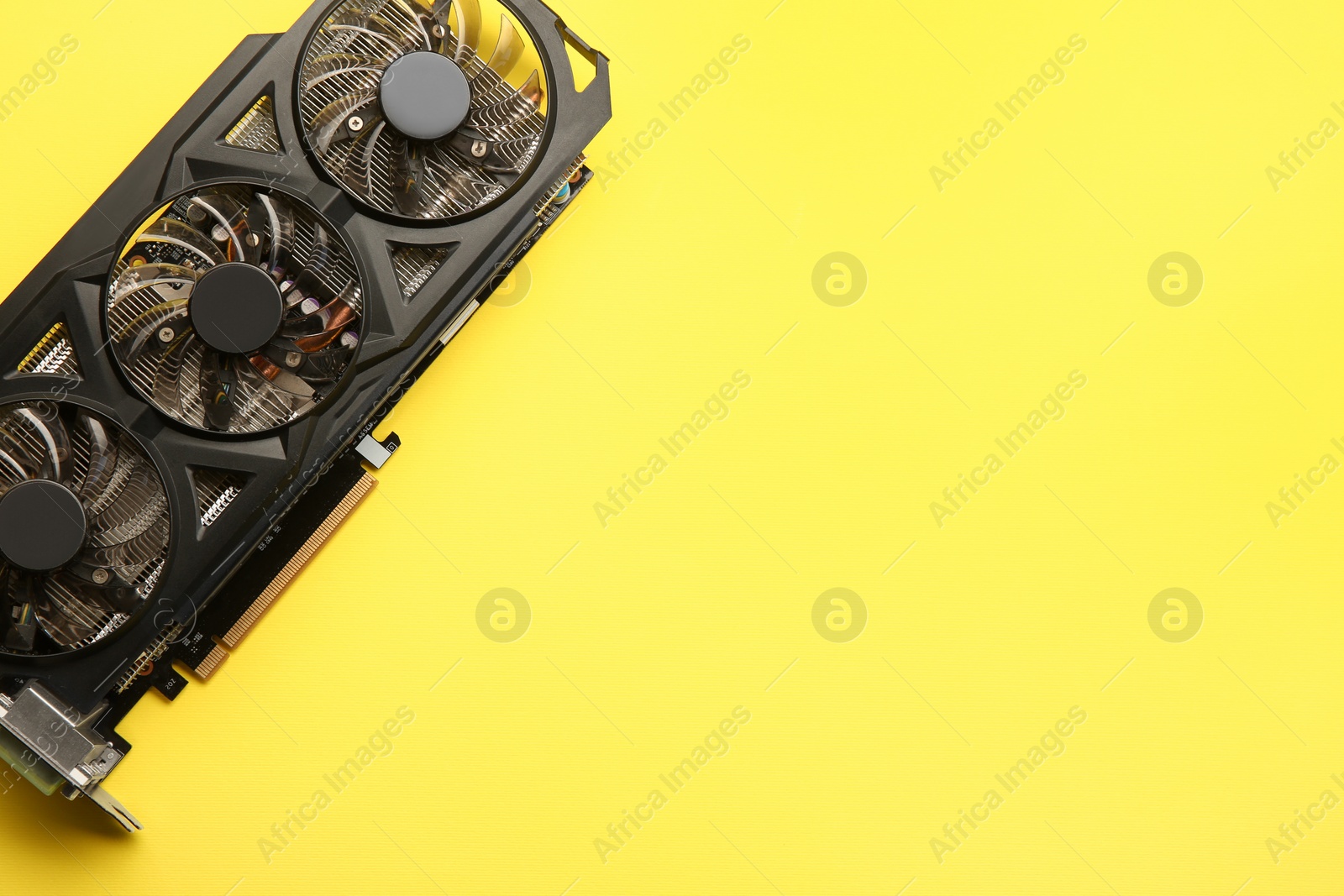 Photo of One graphics card on yellow background, top view. Space for text