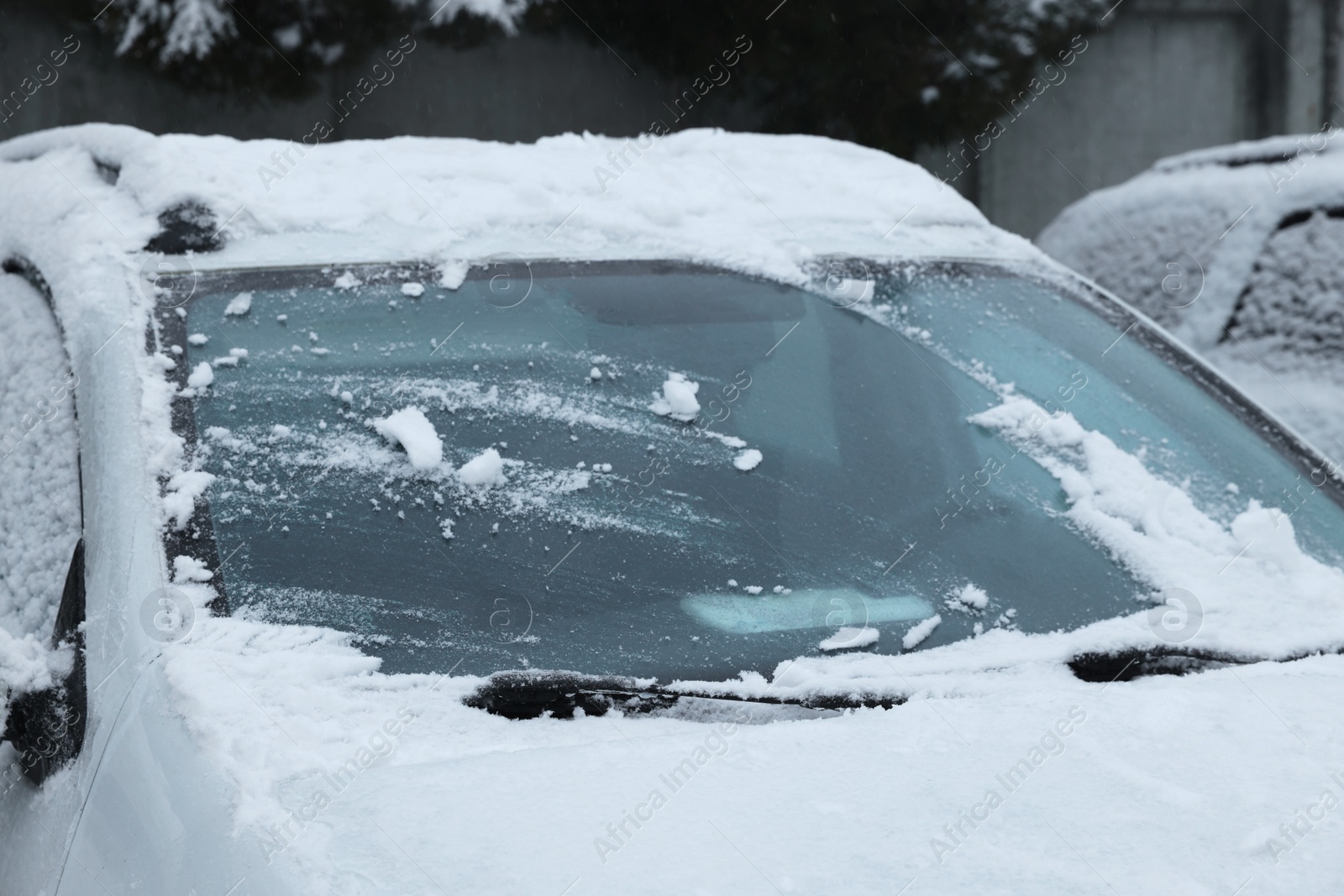 Photo of Car windshield with wiper blades cleaned from snow outdoors on winter day