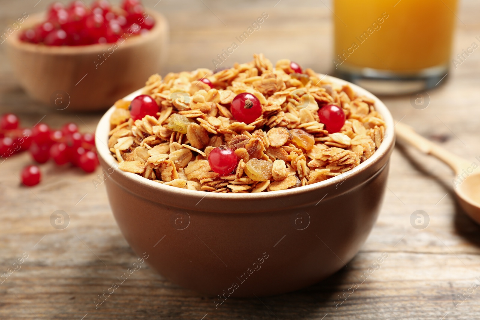 Photo of Muesli with berries served on wooden table. Delicious breakfast