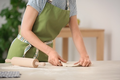 Photo of Woman preparing dough on table in kitchen