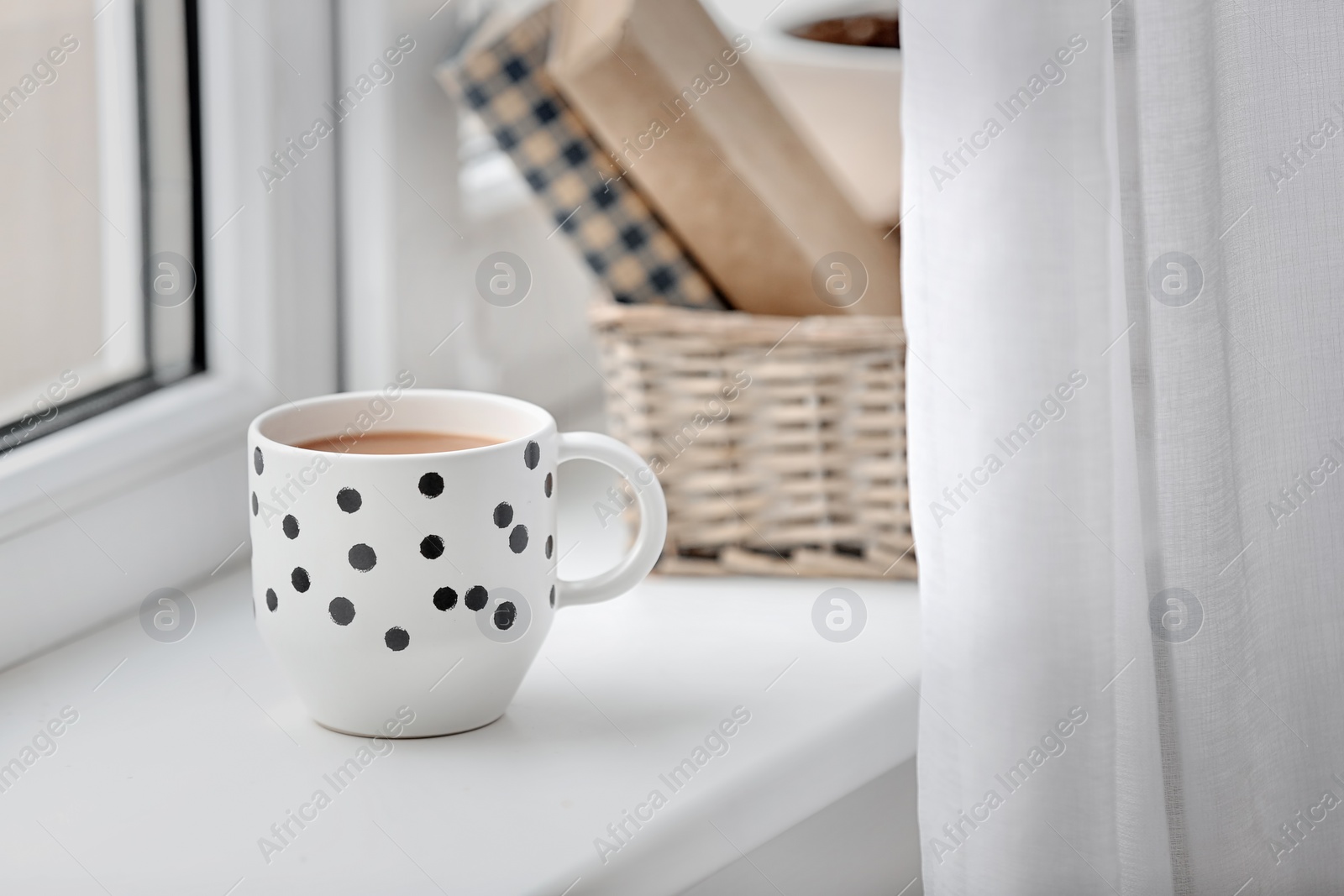 Photo of Cup of hot coffee on windowsill