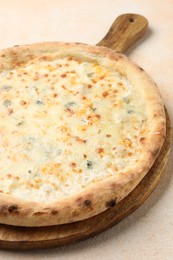 Photo of Delicious cheese pizza on beige textured table, closeup