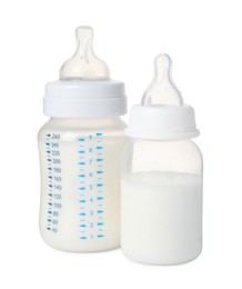 Two feeding bottles with infant formula on white background