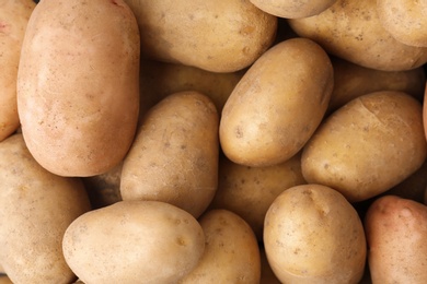 Fresh ripe organic potatoes as background, top view