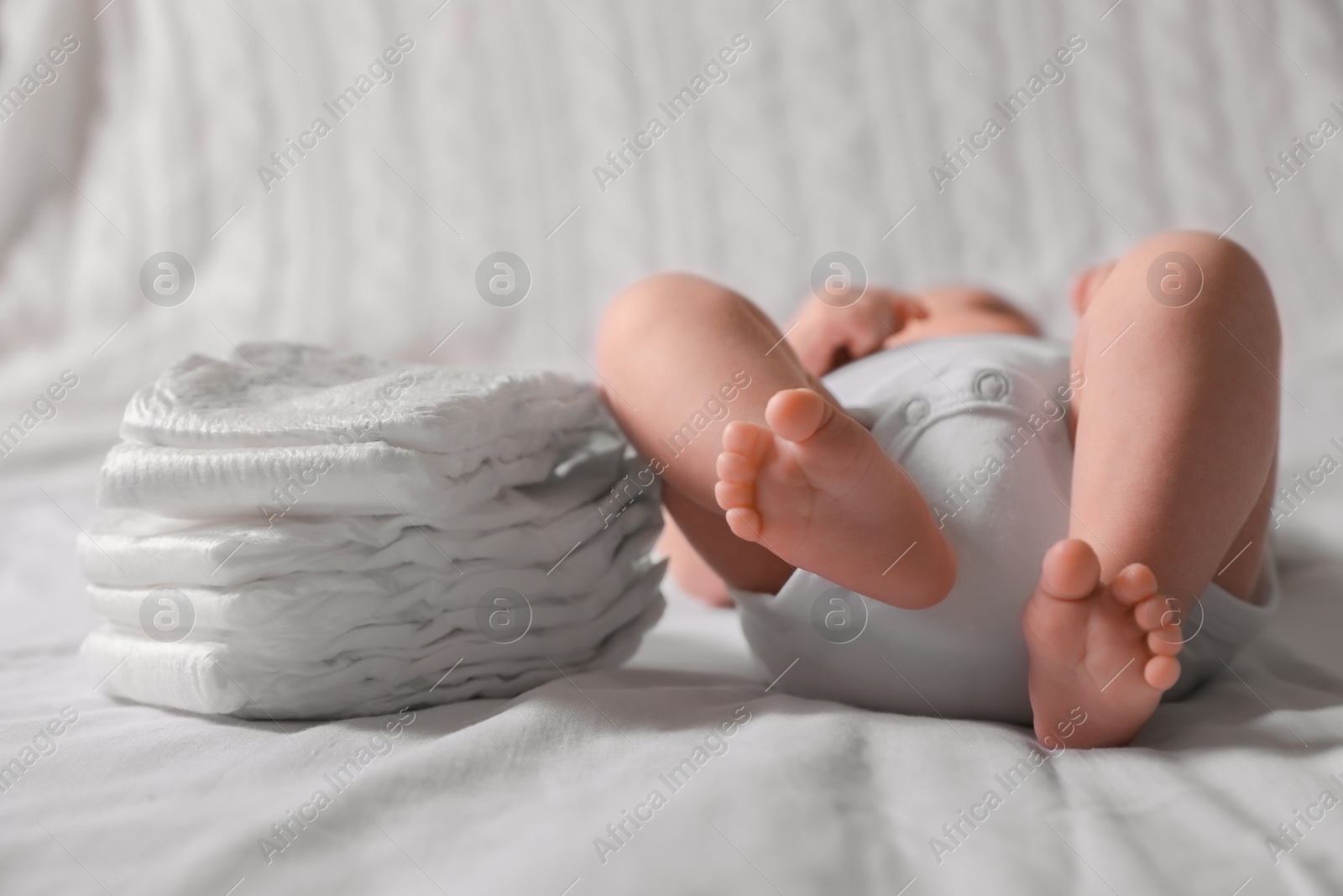 Photo of Little baby lying at bed, focus on legs