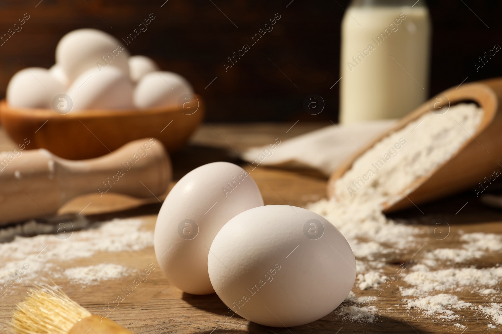 Photo of Raw chicken eggs on wooden table, closeup