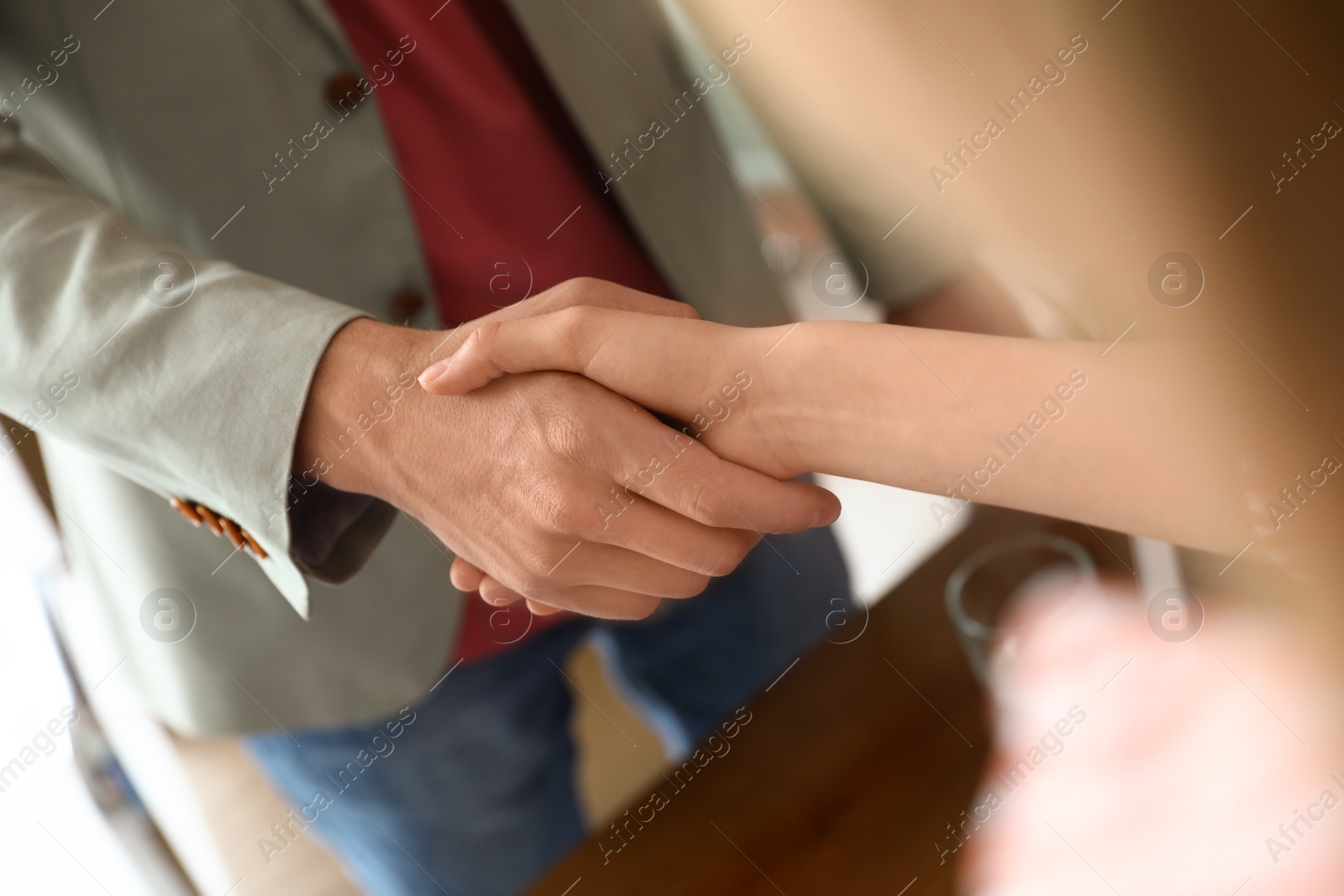 Photo of Business partners shaking hands after meeting, closeup