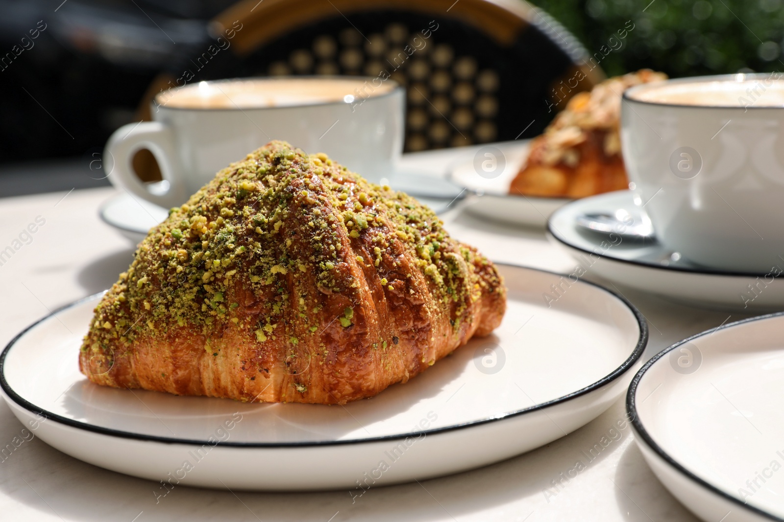 Photo of Delicious croissant and coffee served on white table