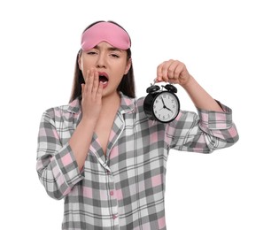 Photo of Tired woman with sleep mask and alarm clock yawning on white background. Insomnia problem