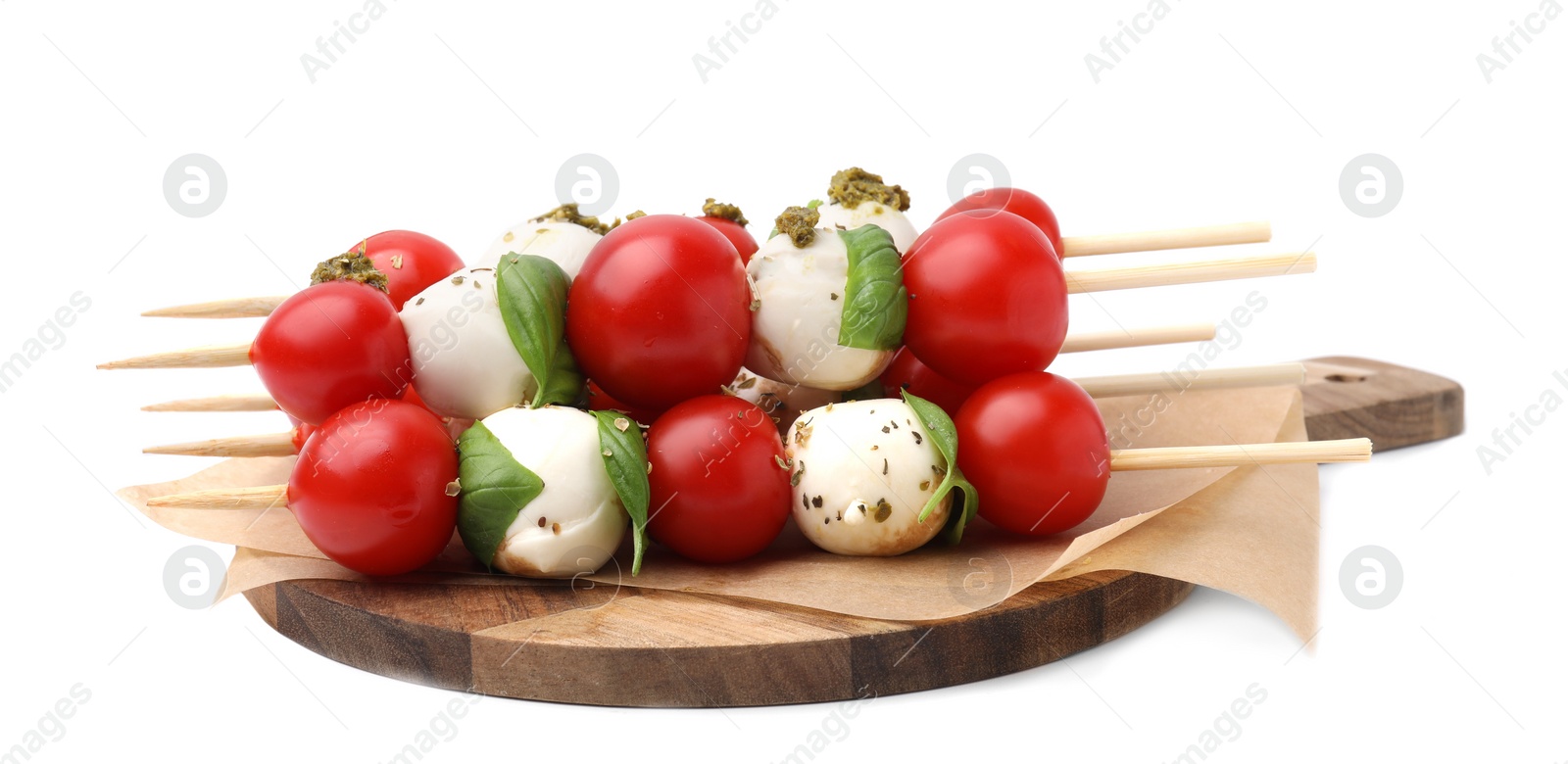 Photo of Caprese skewers with tomatoes, mozzarella balls, basil and pesto sauce on white background