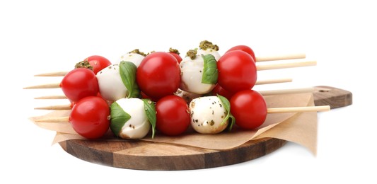 Caprese skewers with tomatoes, mozzarella balls, basil and pesto sauce on white background