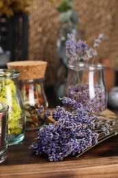 Many different herbs and dry lavender flowers on wooden board, space for text