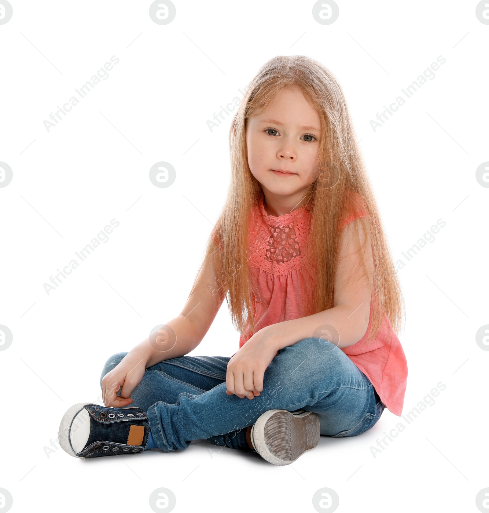 Photo of Cute little girl in casual outfit sitting on white background