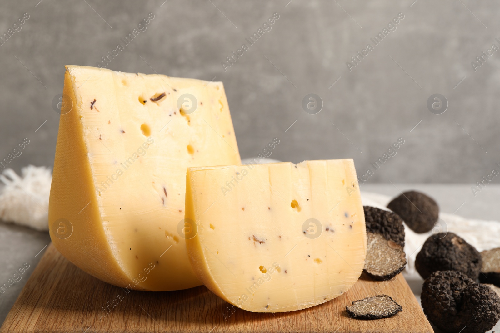 Photo of Delicious cheese and fresh black truffles on table