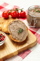 Photo of Fresh bread with delicious liver pate on white wooden table, closeup view