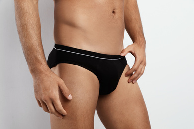 Man in black underwear on white background, closeup