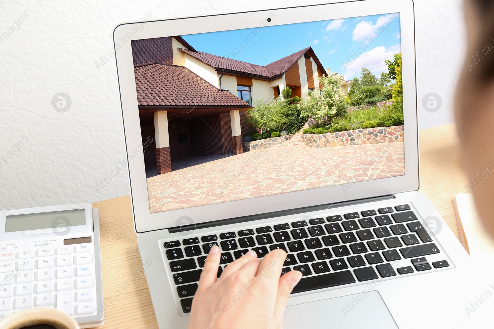 Image of Businesswoman or real estate agent looking through online property portfolio using laptop, closeup