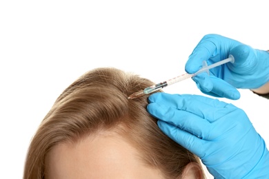 Photo of Young woman with hair loss problem receiving injection on white background, closeup