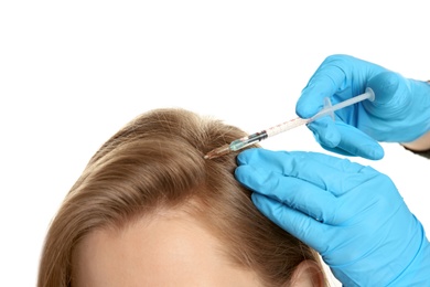 Young woman with hair loss problem receiving injection on white background, closeup