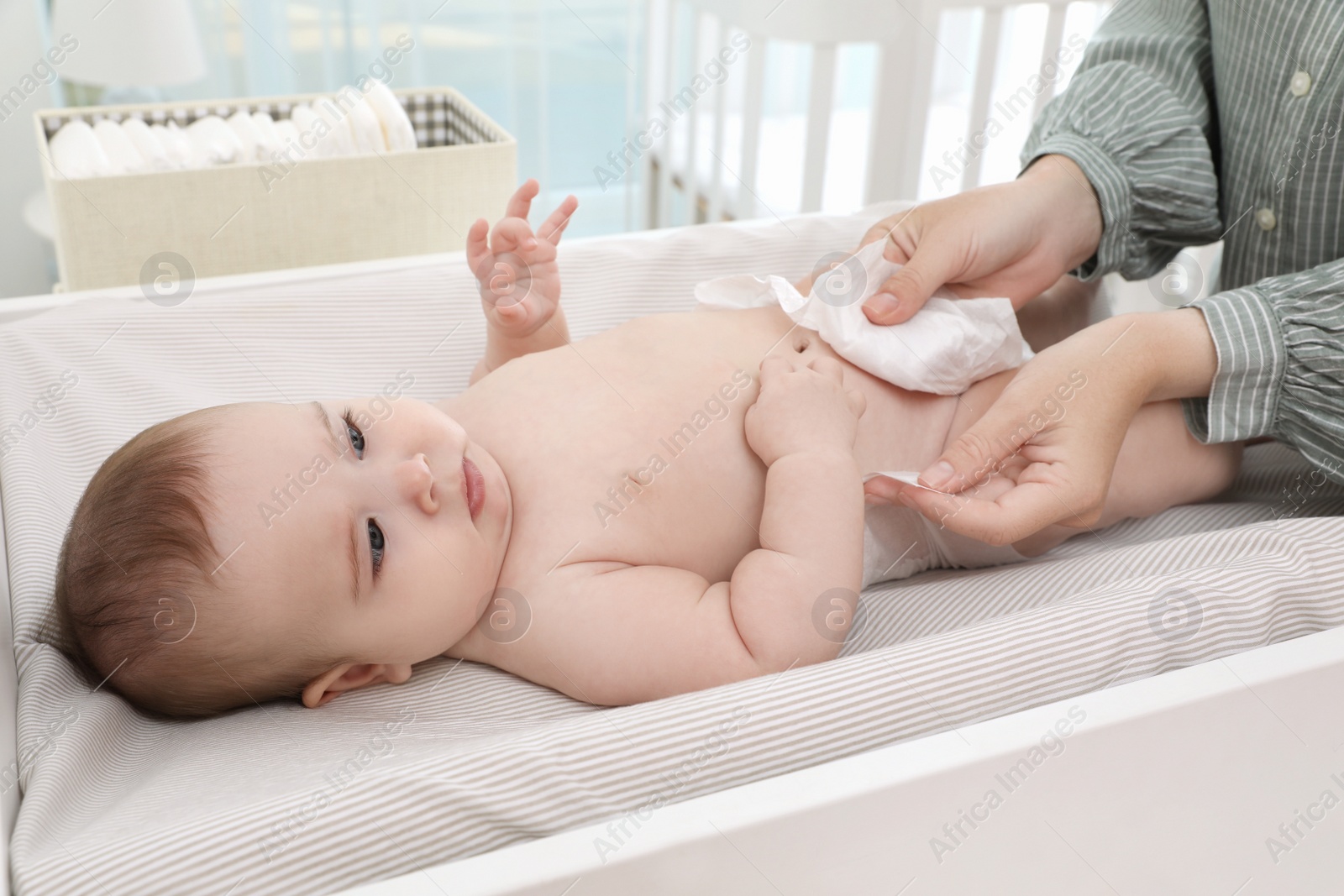 Photo of Mother changing baby's diaper on table at home