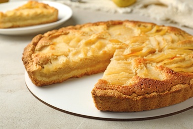 Photo of Cut delicious sweet pear tart on table, closeup