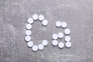 Symbol Ca (Calcium) made of pills on gray background, top view