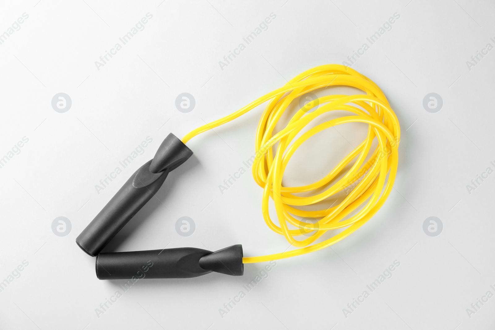 Photo of Skipping rope on white background, top view. Sports equipment