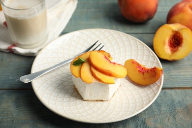 Photo of Delicious peach dessert on blue wooden table