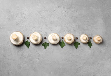 Photo of Flat lay composition with fresh champignon mushrooms on grey background