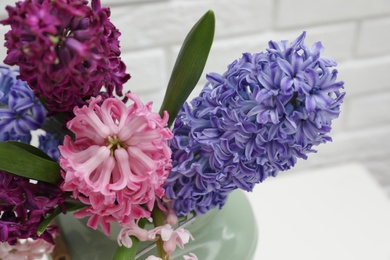 Photo of Beautiful hyacinths in metal can on blurred background, closeup. Spring flowers