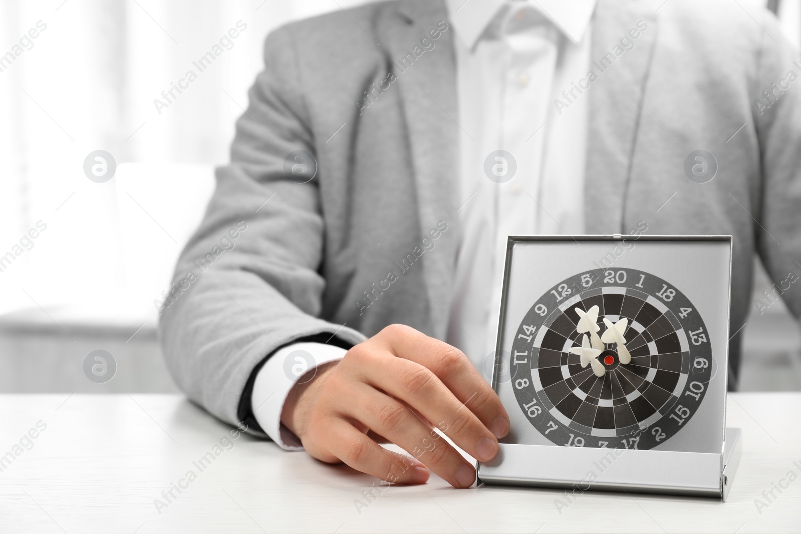 Photo of Man with darts at table. Business trainer concept