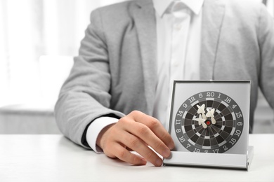 Photo of Man with darts at table. Business trainer concept