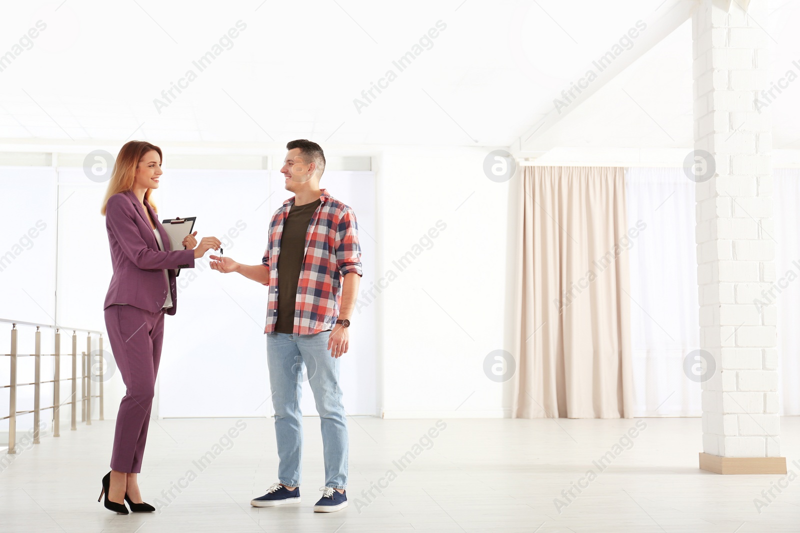 Photo of Real estate agent giving apartment keys to client indoors. Space for text