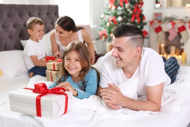 Photo of Happy parents and children exchanging gifts on Christmas morning at home