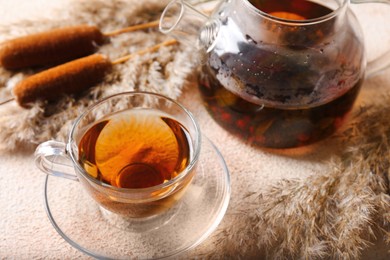 Hot tea and beautiful dry reed on beige textured table