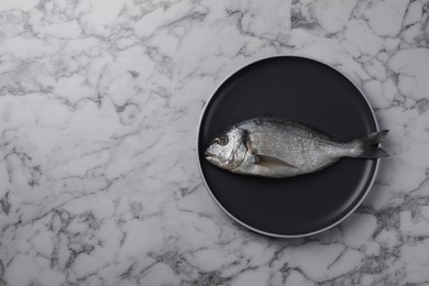 Photo of Fresh dorado fish on white marble table, top view. Space for text