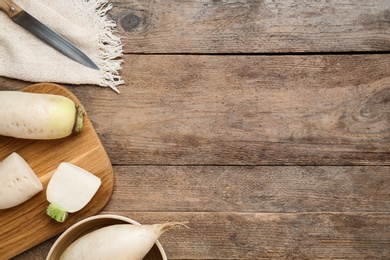 Photo of Raw white turnips on wooden table, flat lay. Space for text