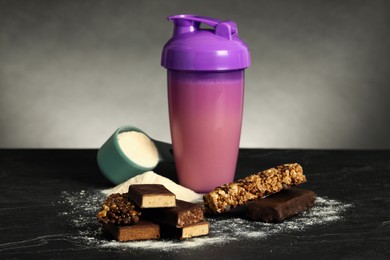 Different energy bars, protein cocktail and powder on black table